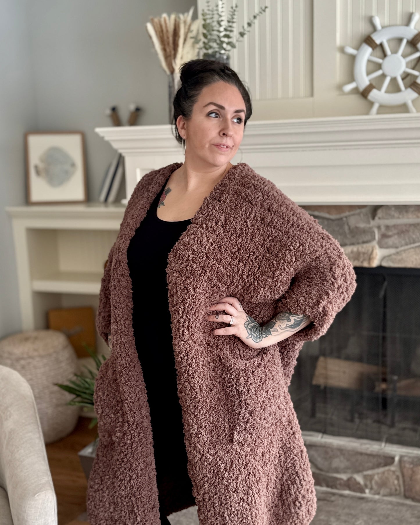 Woman wearing a brown teddy coat in a living room setting.