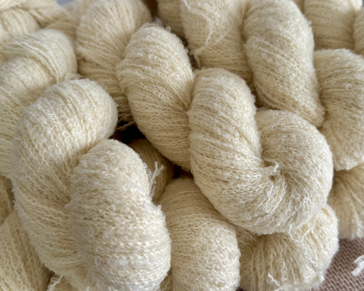 skeins of natural colored boucle wool yarn.