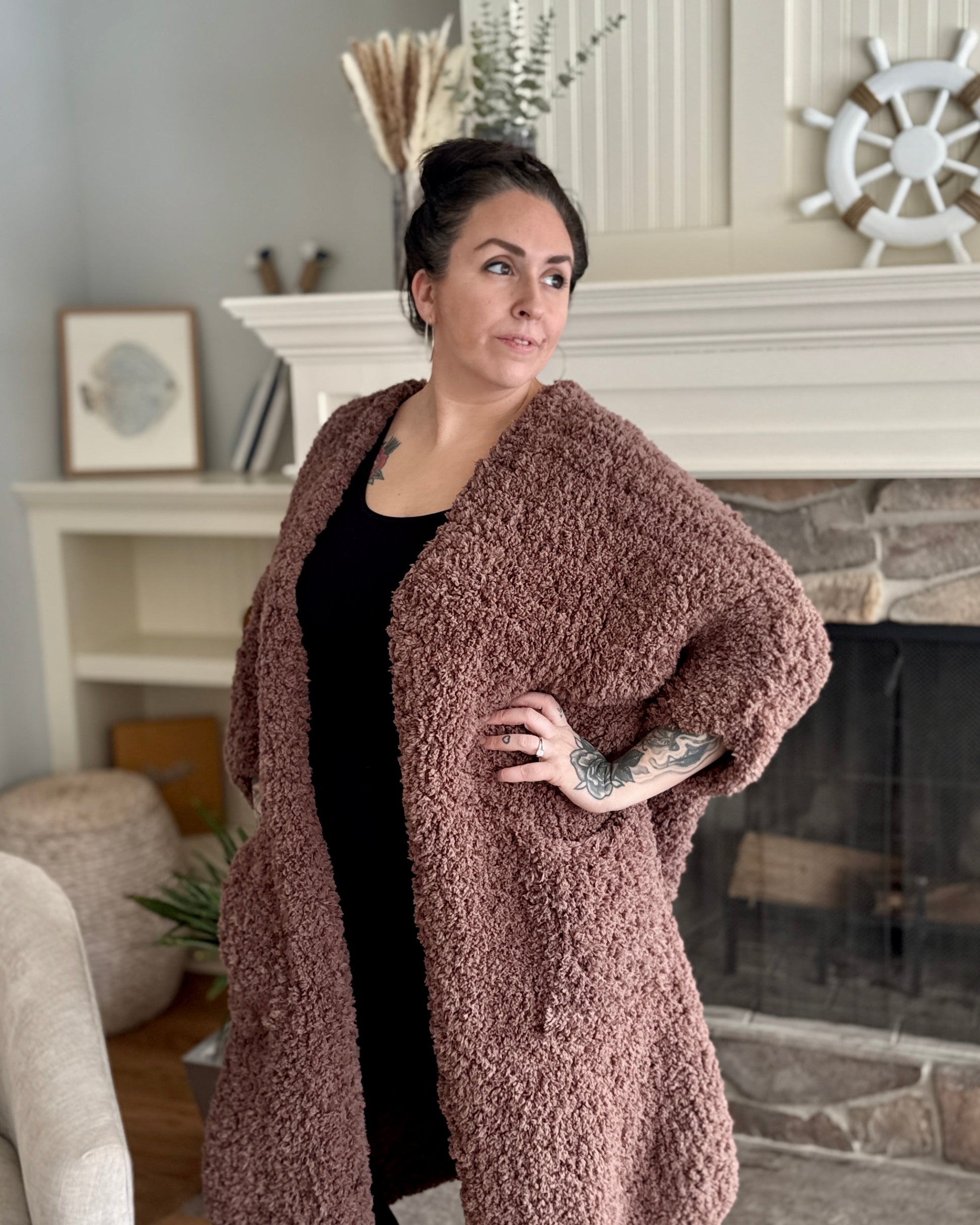 Woman wearing a brown teddy coat in a living room setting.