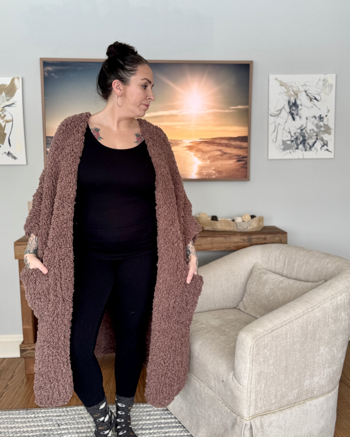 Woman wearing a long brown cardigan in a living room setting