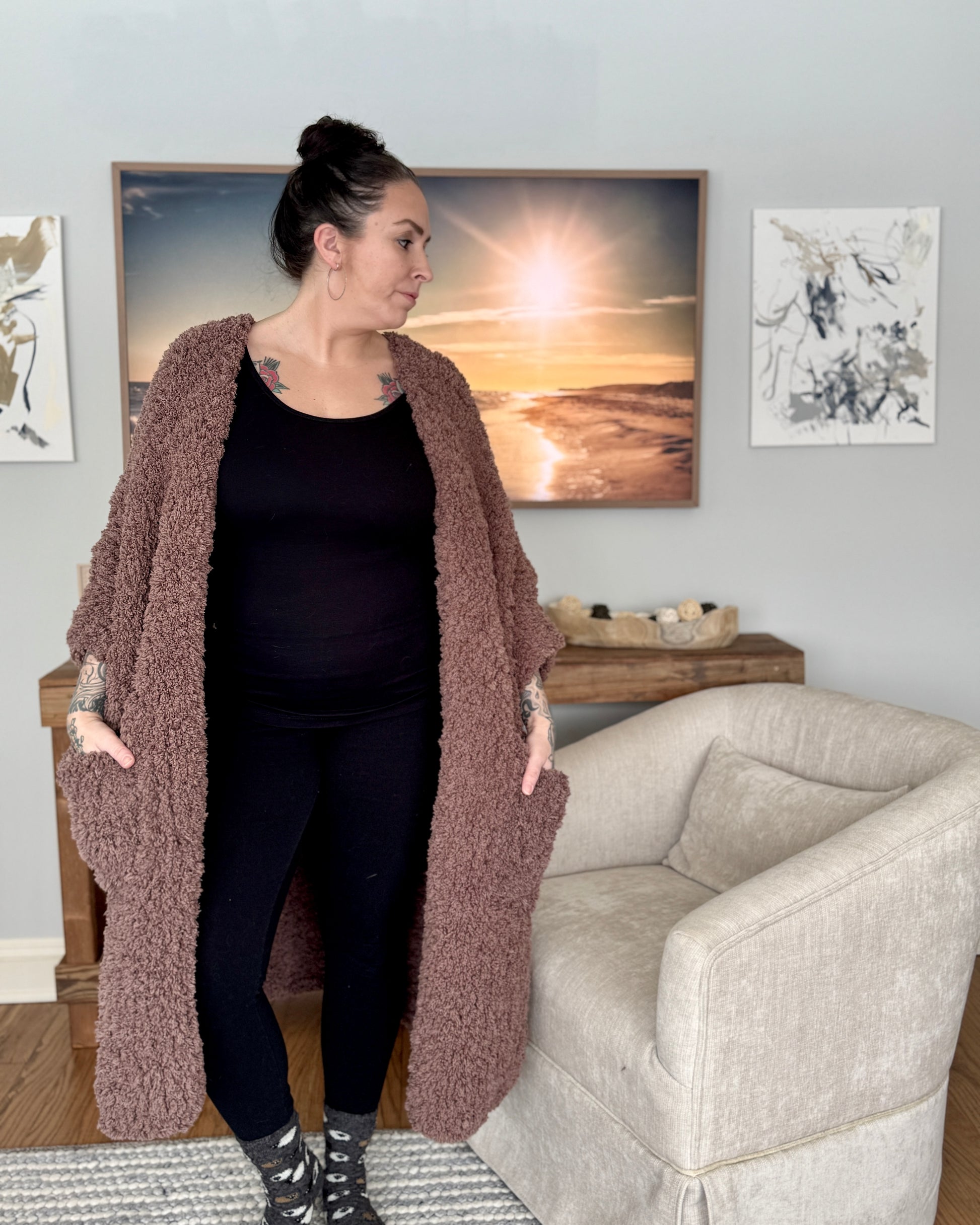 Woman wearing a long brown cardigan in a living room setting